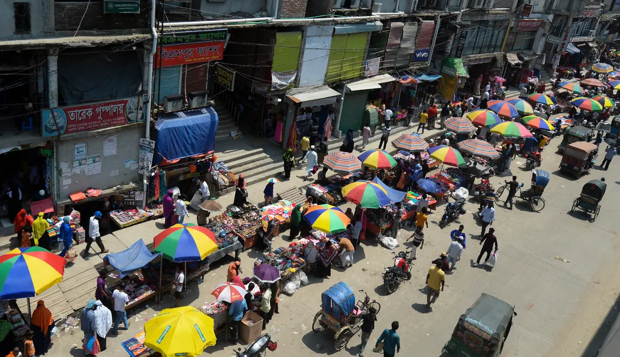 Warga memadati jalan yang dipenuhi lapak pedagang di area pasar tradisional selama karantina wilayah masih diberlakukan pemerintah setempat di Dhaka, Bangladesh (12/5/2020). (AFP/Munir Uz Zaman)