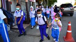 Para siswa tiba di Sekolah Pimarnvit, Provinsi Narathiwat, Thailand, 20 Mei 2022. Thailand melanjutkan sekolah tatap muka secara nasional untuk tahun ajaran baru setelah bertahun-tahun terganggu karena pandemi COVID-19. (Madaree TOHLALA/AFP)