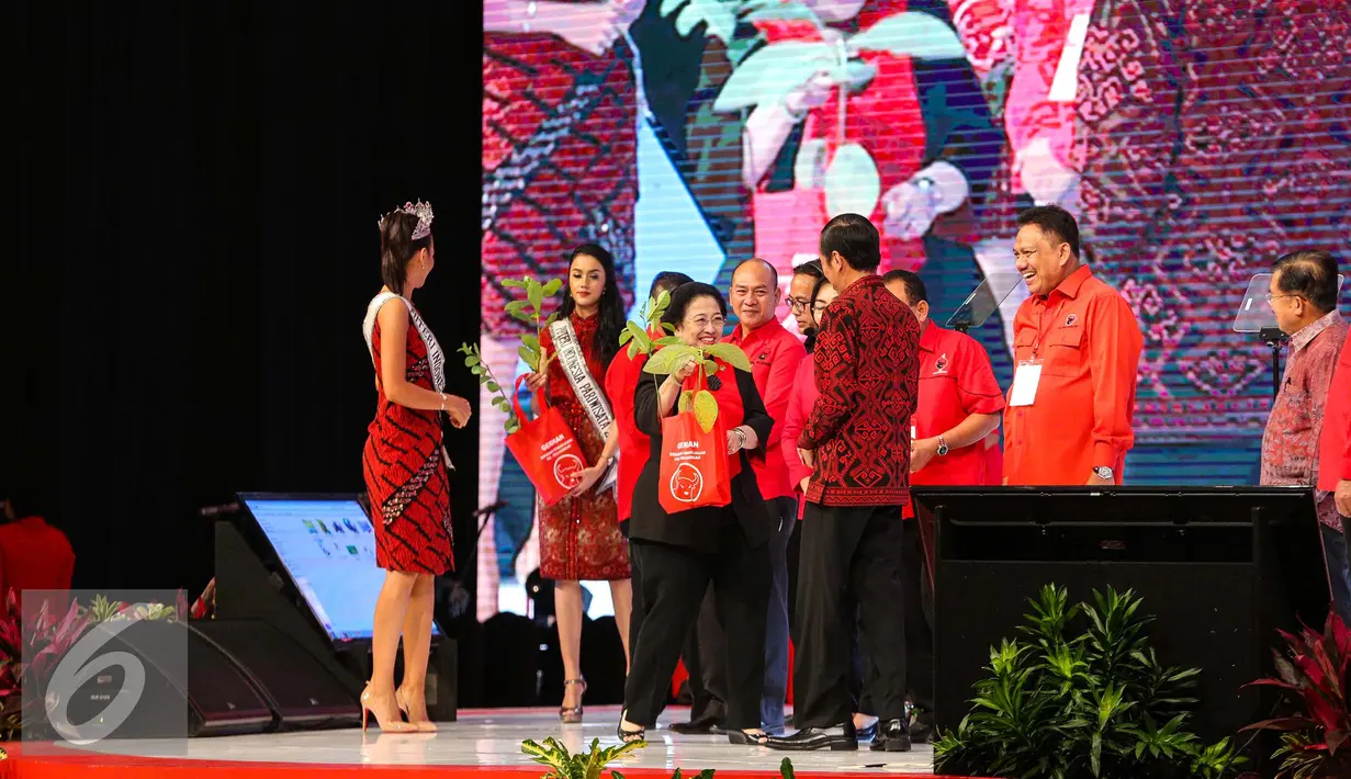 Ketua Umum PDIP Megawati Soekarnoputri memberikan bibit tanaman kepada Presiden Jokowi saat HUT PIDP ke-44 di JCC, Jakarta Pusat, Selasa (10/1). Usai memberikan tumpeng, Megawati memberikan bibit tanaman kepada Presiden Jokowi.(Liputan6.com/Faizal Fanani)