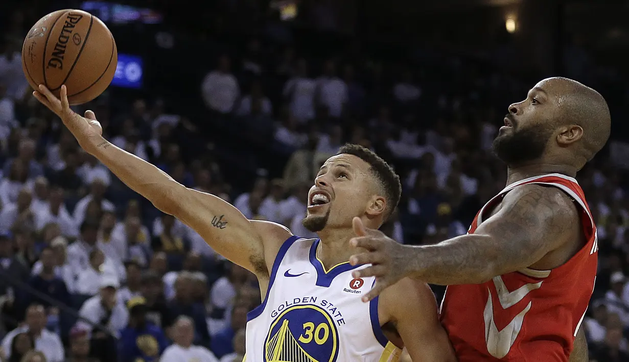 Aksi pebasket Warriors, Stephen Curry (kiri) melakukan tembakan lays up saat diadang pebasket Houston Rockets, PJ Tucker pada laga perdana NBA 2017 di Oracle Arena, Oakland, (17/10/2017).  Rockets menang 122-121. (AP/Ben Margot)