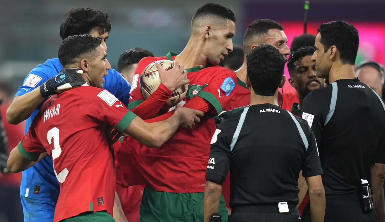 Sejumlah pemain Maroko yang tidak puas dengan kepemimpinan wasit menghampiri Abdulrahman Al Jassim selaku pengadil lapangan setelah peluit panjang babak kedua dibunyikan. (AP Photo/Francisco Seco)