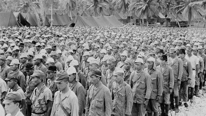 Sebagian dari 2.600 tawanan perang Jepang yang merupakan garnisun musuh di Pulau Rota berbaris di tahanan benteng perang Guam, Kepulauan Marianas, 5 September 1945. Tanggal 2 September 2020 menjadi peringatan 75 tahun penyerahan resmi Jepang kepada Amerika Serikat. (AP Photo, File)