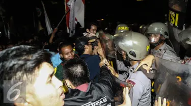 Massa aksi terlibat bentrok dengan polisi yang berjaga saat menggelar aksi unjuk rasa di depan Istana Negara, Kamis (12/1). Dalam aksinya mereka menuntut Presiden Jokowi-JK untuk membuat kebijakan yang pro terhadap rakyat. (Liputan6.com/Faizal Fanani)