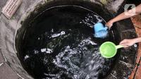 Warga keturunan Tionghoa menggayung air saat membersihkan diri di salah satu sumur Vihara Gayatri, Depok, Jawa Barat, Minggu (15/1/2023). (merdeka.com/Iqbal S. Nugroho)
