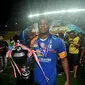 Pemain Belakang Arema Cronus, Victor Igbonefo berjalan sambil memegang piala usai mengalahkan Sriwijaya FC di final SCM Cup 2015 di Stadion Jakabaring,Selasa (27/1/2015). Arema Cronus unggul 1-0 atas Sriwijaya FC. (Liputan6.com/Johan Tallo)