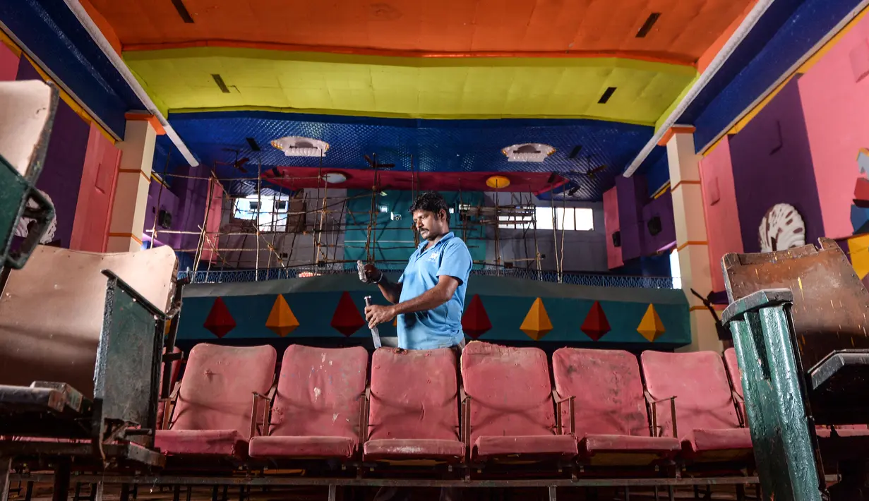Pekerja melakukan perawatan dan pemeliharaan di aula bioskop sebagai persiapan kemungkinan pembukaan kembali setelah pelonggaran pembatasan Covid-19, di Chennai, Sabtu (3/10/2020). Jumlah kematian di India akibat virus corona meningkat melewati 100.000 pada Sabtu, 3 Oktober 2020. (Arun SANKAR/AFP)