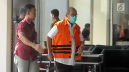 Bupati Bandung Barat Abubakar mengenakan masker dan membawa tongkat berjalan menuju ruang pemeriksaan di gedung KPK, Jakarta, Selasa (8/5). (Merdeka.com/Dwi Narwoko)
