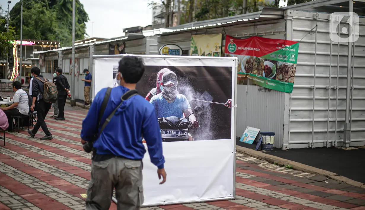Pengunjung mengamati karya Pameran Fotografi Rekam Jakarta 2019-2020 di Thamrin 10, Jakarta, Jumat (4/12/2020). Pameran yang mengangkat tema Ragam Cerita Ibu Kota Sebelum dan Saat Pandemi COVID-19 tersebut berlangsung hingga 13 Desember 2020. (Liputan6.com/Faizal Fanani)