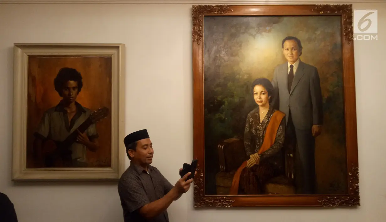 Pelayat memotret koleksi lukisan di rumah duka Presiden ke-3 RI BJ Habibie, Patra Kuningan, Jakarta, Rabu (11/9/2019). BJ Habibie meninggal pada Rabu, 11 September 2019 pukul 18.05 WIB. (Liputan6.com/Angga Yuniar)