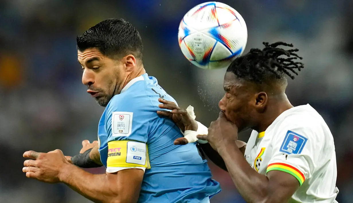 Pemain Ghana Mohammed Salisu (kanan) berebut bola dengan pemain Uruguay Luis Suarez pada pertandingan sepak bola Grup H Piala Dunia 2022 di Stadion Al Janoub, Al Wakrah, Qatar, 2 Desember 2022. Uruguay mengalahkan Ghana 2-0, namun tetap tak lolos ke babak 16 besar Piala Dunia 2022. (AP Photo/Ashley Landis)