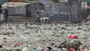 Seorang anak berjalan dekat permukiman kumuh yang berdiri di atas tumpukan sampah di Kampung Bengek, Jakarta Utara, Selasa (3/9/2019). Permukiman kumuh ini berdiri di atas rawa yang membeku karena timbunan sampah plastik, kasur bekas hingga limbah rumah tangga. (Liputan6.com/Faizal Fanani)