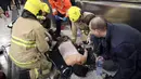 Petugas medis memberikan pertolongan pada korban kebakaran di Stasiun Tsim Sha Tsui, Hong Kong (10/2). Insiden ini terjadi di kereta yang berangkat dari Stasiun Admiralty menuju Tsim Sha Tsui pada Jumat (10/2/2017) malam. (Handout / Apple Daily / AFP)