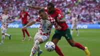 Pemain Timnas Kroasia, Josip Juranovic (kiri) berebut bola dengan pemain Timnas Maroko, Sofiane Boufal dalam laga matchday pertama Grup F Piala Dunia 2022 di Al Bayt Stadium, Qatar, Rabu (23/11/2022) sore WIB. (AP/Thanassis Stavrakis)
