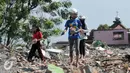Sejumlah warga mengumpulkan batu bata merah dari sisa puing-puing rumah pembongkaran di Bukit Duri, Jakarta, Kamis (29/9). Batu bata merah yang dikumpulkan akan kembali dijual oleh warga dengan harga yang sangat murah. (Liputan6.com/Yoppy Renato)