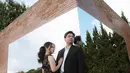 Dalam pemotretan bertema dramatis, mereka menghadirkan konsep yang lebih elegan dan berkelas. Indah tampil memukau dalam gaun hitam beraksen renda dengan rambut yang ditata rapi, sedangkan Frans memilih setelan jas hitam yang membuatnya terlihat berwibawa. Latar dinding bata dan cermin besar berpadu dengan refleksi langit biru, menciptakan hasil foto yang artistik dan memanjakan mata.  (Liputan6.com/IG/@fransfaisal_)