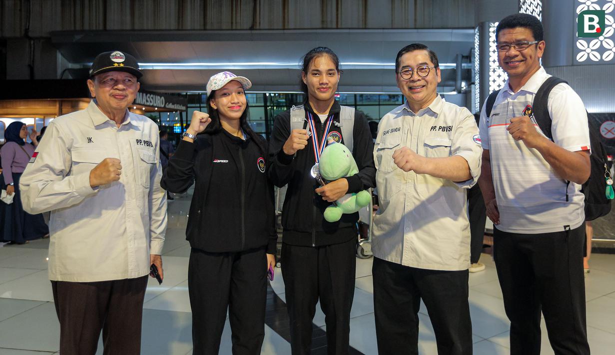 <p>Dua pemain Timnas voli putri Indonesia U-18, Tazma Aprilia dan Junaida Santi berpose dengan pengurus PBVSI (dari kiri) Wakil Ketua Umum II PBVSI Irjen Pol (Purn) Djoko Sardono, Wakil Sekjen PBVSI Gilang Iskandar dan Wakil Kabid Binpres PBVSI, Loudry Maspaitella dalam acara penyambutan di Terminal 3 Bandara Soekarno Hatta, Tangerang, Jumat (14/6/2024) usai menempati peringkat kedua pada turnamen bola voli putri Princess Cup 2024. (Bola.com/Bagaskara Lazuardi)</p>