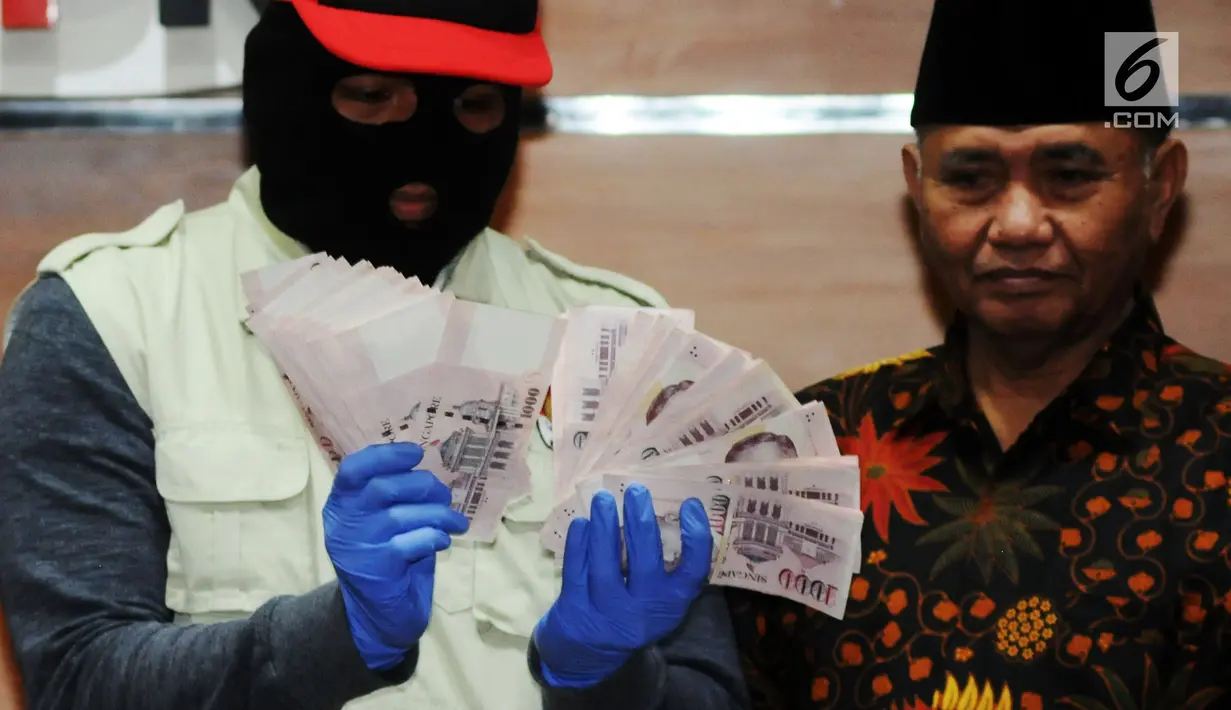 Pimpinan KPK, Agus Rahardjo (kanan) bersama Penyidik menunjukan barang bukti Oprasi Tangkap Tangan (OTT) uang 130.000 Dollar Singapore atau setara Rp 1,3 milyar di gedung KPK, Jakarta, Rabu (29/8). (merdeka.com/Dwi Narwoko)