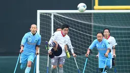 Pemain FC Alvorada Kawasaki (tengah) menendang bola saat pertandingan final kejuaraan nasional melawan  FC Kyushu Bairaor di Fujitsu Stadium Jepang. Kejuaraan ini diperuntukkan untuk orang yang memiliki cacat fisik. (Aflo/Rex Shutterstock/Dailymail)