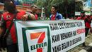 Karyawan Eks 7-Eleven membentangkan spanduk saat Demo di depan Kantor Pengusaha Sungkono Honoris, Jakarta, Rabu (9/1). Mereka menuntut pembayaran uang pesangon yang sampai saat ini belum mereka terima semenjak 7-Eleven tutup. (Liputan6.com/Johan Tallo)