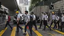 Para siswa sekolah mengenakan topeng dan helm berjalan di luar St. Paul's College selama protes di Hong Kong, Selasa (3/9/2019). Puluhan ribu siswa di Hong Kong mogok sekolah di hari pertama tahun ajaran baru. (AP Photo/Kin Cheung)