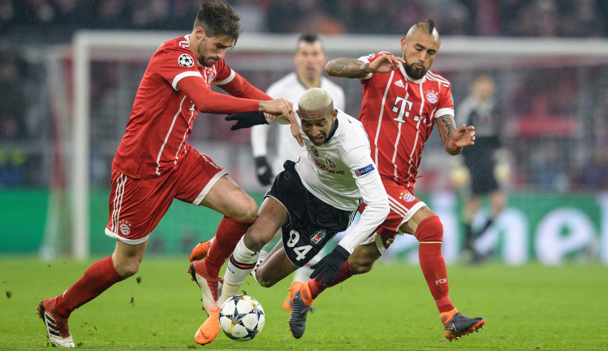 Pemain Besiktas, Talisca berebut bola dengan pemain Bayern Munchen, Javi Martinez dan Arturo Vidal pada pertandingan pertama babak 16 besar Liga Champions di Allianz Arena, Selasa (20/2). Bayern menang telak dengan skor 5-0. (Matthias Balk/dpa via AP)