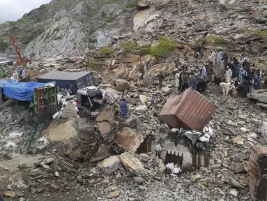 Petugas penyelamat dan sukarelawan mencari korban yang selamat setelah tanah longsor di dekat kota perbatasan Torkham, Pakistan, Selasa (18/4/2023). (AP Photo/Muhammad Sajjad)