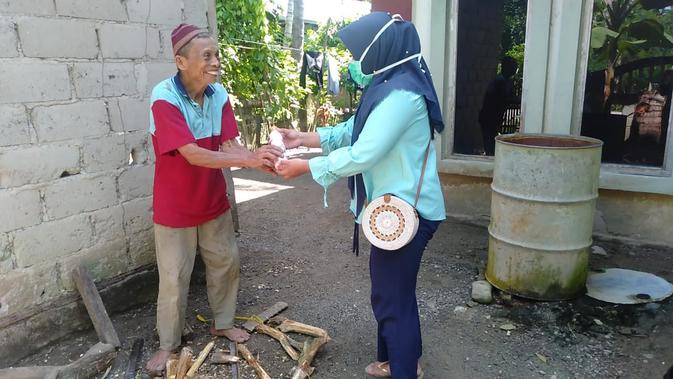 Ketua Sanggar Seni Marendeng Rezki Amalia saat membagikan sabun antiseptik secara gratis kepada warga