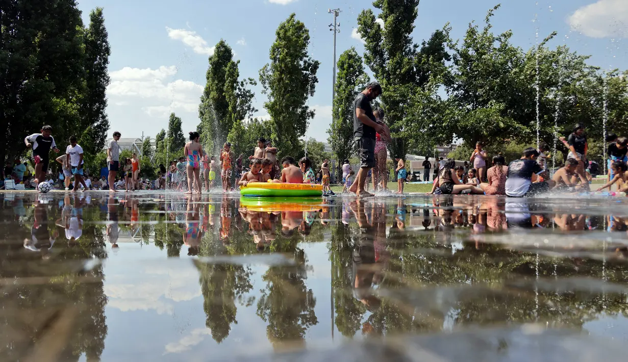 Mulai akhir pekan ini, Eropa bagian selatan akan kembali menghadapi suhu ekstrem yang melebihi 40°C. Tampak dalam foto, orang-orang mendinginkan diri di bawah air mancur di area rekreasi Madrid Rio selama gelombang panas pertama musim panas di Madrid, pada 28 Juni 2025. (Thomas COEX/AFP)