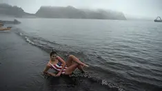 Wisatawan menikmati air panas di danau kawah Pulau Deception, Antartika, 6 Maret 2016. Danau air panas itu berasal dari kaldera gunung berapi aktif yang rusak pada tahun 1967 dan 1969 hingga membentuk danau kawah berair panas. (AFP PHOTO/Eitan Abramovich)