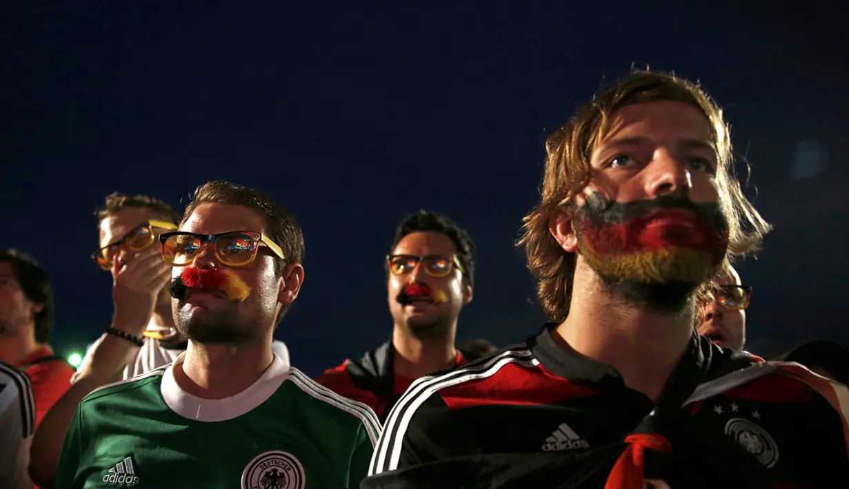 Raut kecemasan terlihat di wajah suporter Timnas Jerman yang menyaksikan laga Jerman kontra Aljazair melalui layar lebar di pantai Copacabana, Rio de Janeiro, (1/7/2014). (REUTERS/Pilar Olivares)