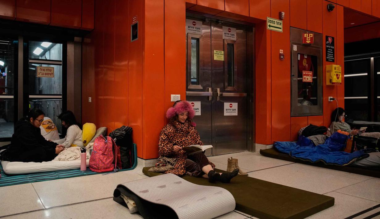Langkah ini dilakukan menyusul eskalasi konflik dan gelombang serangan rudal dari Iran yang menargetkan pusat-pusat kota Israel dalam beberapa hari terakhir. Tampak dalam foto, orang-orang berlindung di stasiun metro bawah tanah saat sirene serangan udara memperingatkan datangnya rudal Iran di Tel Aviv, Israel, Sabtu, 7 Maret 2026. (AP Photo/Ohad Zwigenberg)