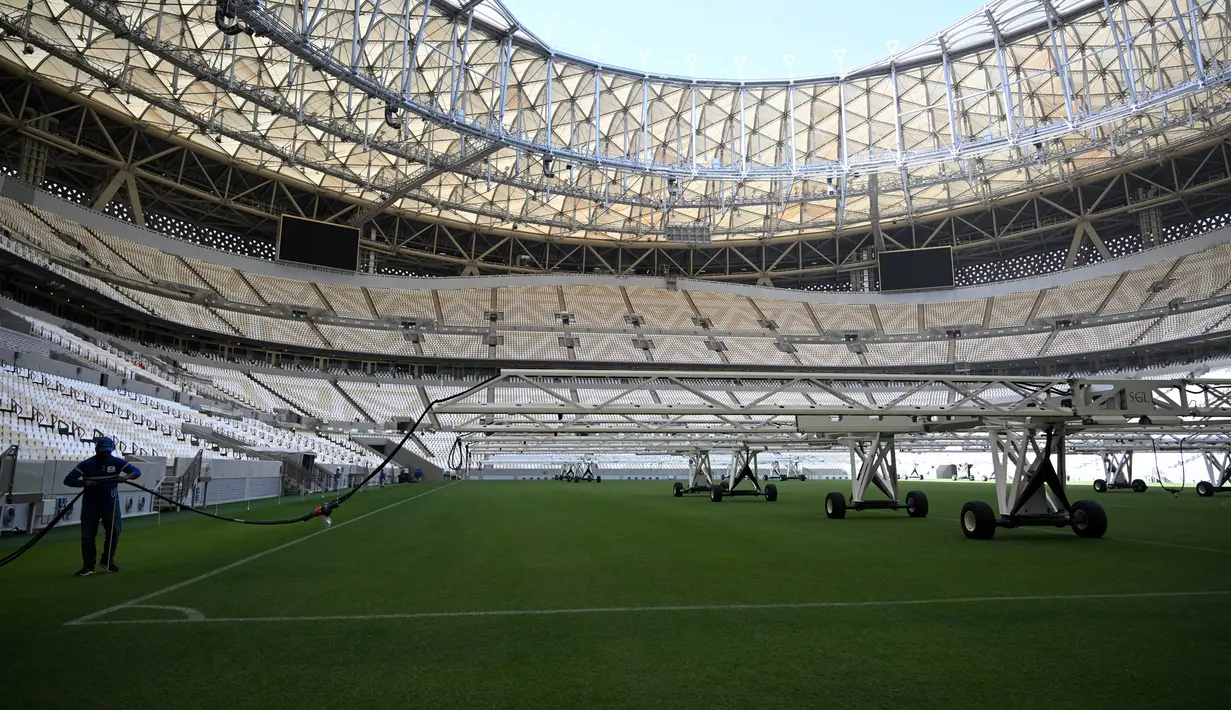 Seorang pria bekerja di lapangan Lusail Stadium, Lusail, Qatar, 28 Maret 2022. Stadion berkapasitas 80 ribu penonton yang terletak di pinggiran Ibu Kota Doha ini akan menjadi tuan rumah final Piala Dunia 2022 pada bulan Desember mendatang. (GABRIEL BOUYS/AFP)