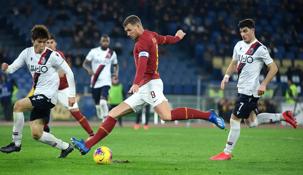 Pemain AS Roma Bosnia Edin Dzeko (tengah) menendang bola saat menghadapi Bologna pada pertandingan pekan ke-23 Serie A Liga Italia di Olimpico Stadio, Roma, Italia, Jumat (7/2/2020). AS Roma kalah dari Bologna 2-3. (Filippo MONTEFORTE/AFP)