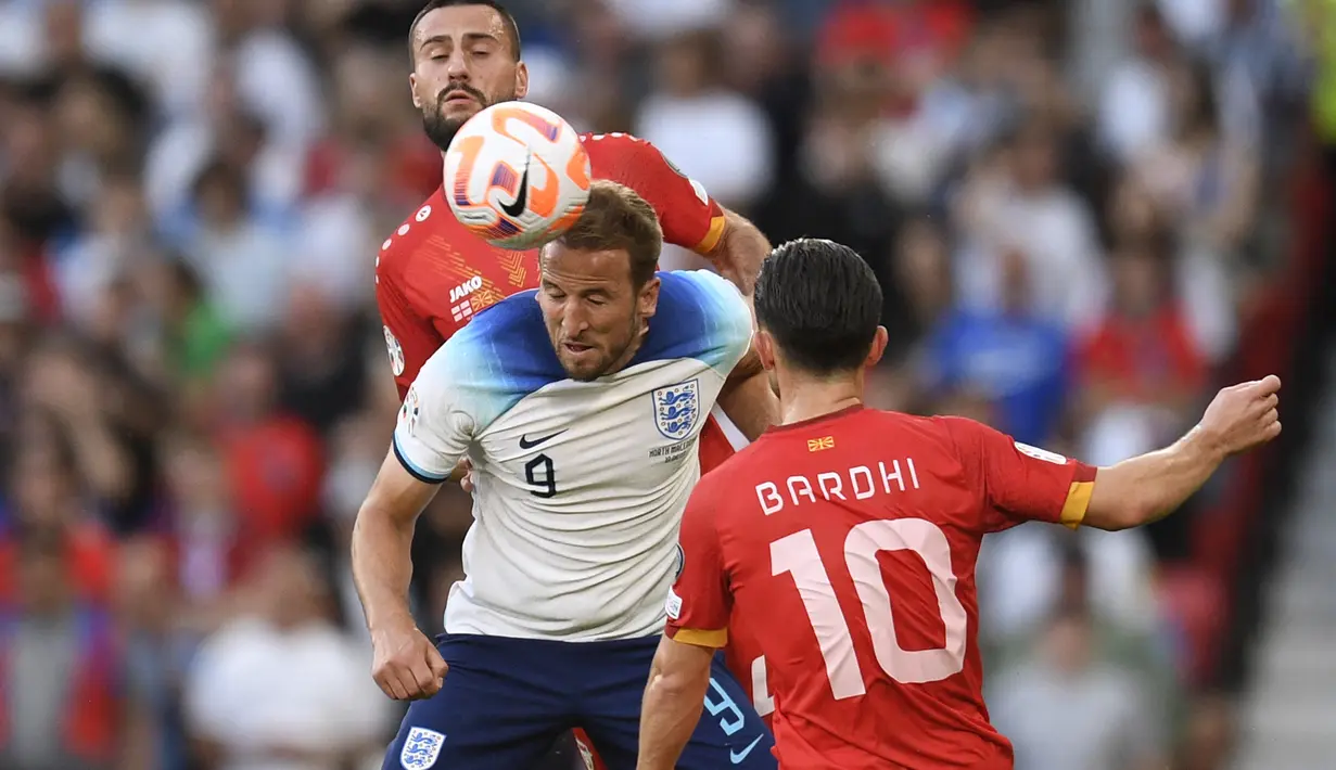 Striker Timnas Inggris, Harry Kane (tengah) ditempel ketat dua pemain Makedonia Utara, Gjoko Zajkov (kiri) dan Enis Bardhi pada laga Grup C Kualfikasi Euro 2024 di Old Trafford, Manchester (19/6/2023). Harry Kane menjadi pemain aktif dengan jumlah gol terbanyak bagi Timnas Inggris dengan koleksi 58 gol dari 84 laga sejak melakukan debut pada 27 Maret 2015. Dua gol terakhirnya dibuat saat Inggris menang 7-0 atas Makedonia Utara pada laga Grup C Kualifikasi Euro 2024. (AFP/Oli Scarff)