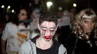 Seorang remaja berdandan serta mengenakan kostum zombie saat mengikuti Zombie Walk dalam Festival Purim di Tel Aviv, Israel (3/3). Acara pesta kostum zombie ini dimeriahkan oleh ratusan orang di Tel Aviv. (AP Photo/Ariel Schalit)