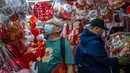 Para pembeli melihat dekorasi Tahun Baru Imlek yang dijual di sebuah kios pinggir jalan di Distrik Sham Shui Po, Hong Kong, 18 Januari 2023. Tahun Baru Imlek 2023 yang disebut Tahun Kelinci akan jatuh pada tanggal 22 Januari. (AP Photo/Anthony Kwan)
