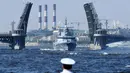 Seorang pelaut menyaksikan kapal perang Rusia berlayar selama parade Hari Angkatan Laut di Sungai Neva, Saint Petersburg, Rusia, Minggu (29/7). (Kirill Kudryavtsev/AFP)