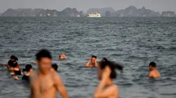 Pengunjung pantai setempat menikmati berenang di pantai Bai Chay di kota Ha Long provinsi timur laut Quang Ninh (16/5/2020). Seiring dengan meredanya virus corona dan otoritas setempat melonggarkan pembatasan perjalanan, pantai Bai Chay kembali didatangi ratusan wisatawan. (AFP/Manan Vatsyayana)