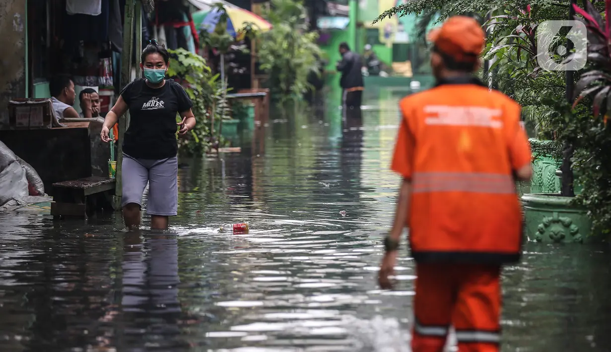 Warga menerobos banjir yang menggenangi lingkungan rumah tempat tinggal mereka di kawasan kecamatan Kebayoran Baru, Jakarta, Senin (25/01/2021). Hujan deras yang mengguyur Jakarta hari ini, Senin (25/1) menyebabkan terjadinya banjir di kawasan permukiman tersebut. (Liputan6.com/Johan Tallo)
