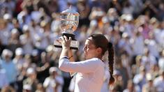 Petenis Latvia,  Jelena Ostapenko mengangkat trofi juara Prancis Terbuka 2017 usai mengalahkan petenis Rumania, Simona Halep di Roland Garros, Paris, (10/6/2017). Ostapenko menang 4-6, 6-4, 6-3. (AP/David Vincent)