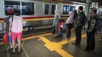 Penumpang berdiri di garis antrean penumpang di Stasiun Juanda, Jakarta, Kamis (10/8). Uji coba garis antrean penumpang juga guna mengurangi bahaya kecelakaan seperti penumpang terjatuh dan terdorong saat keluar masuk KRL. (Liputan6.com/Faizal Fanani)