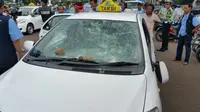 Kaca taksi rusak terkena lemparan batu (Liputan6.com/ Nanda Perdana Putra)