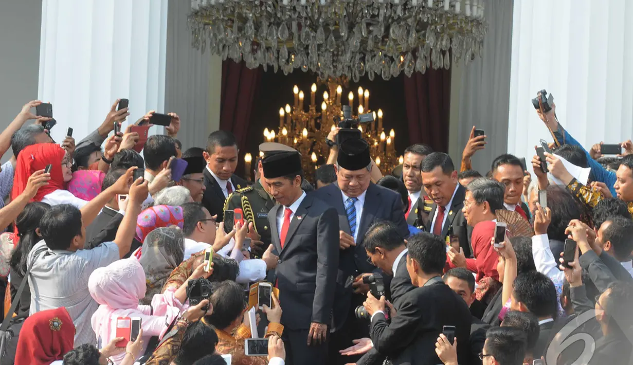Keluar dari Istana Negara, Jokowi dan SBY langsung dikerubuti massa yang ingin bersalaman dan mengambil gambar mereka, Jakarta, Senin (20/10/2014) (Liputan6.com/Herman Zakharia)
