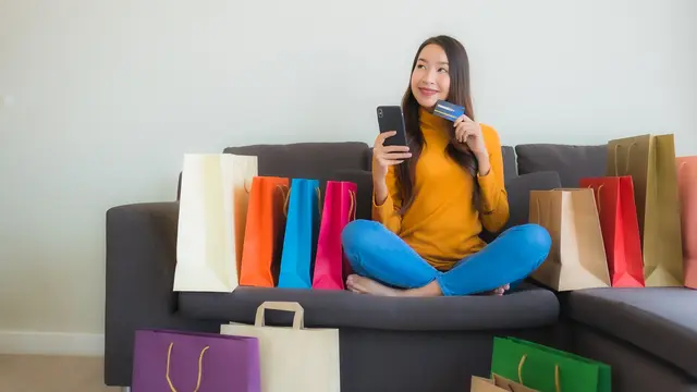 Seorang wanita belanja online dengan metode pembayaran menggunakan Debit BRI