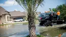 Truk monster menerobos genangan air saat membantu warga yang menjadi korban Badai Harley di Port Arthur, Texas, AS (1/9). Truk raksasa ini menjadi salah satu kendaraan yang diandalkan usai Badai Harley menghantam Texas. (AFP Photo/Emily Kask)