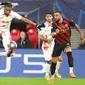 Pemain RB Leipzig Christopher Nkunku (tengah) mengontrol bola udara di depan pemain Manchester City Bernardo Silva (kiri) dan Kyle Walker (kanan) pada pertandingan sepak bola leg pertama babak 16 Liga Champions di Leipzig, Jerman, 22 Februari 2023. Pertandingan berakhir imbang 1-1. (AP Photo/Andreas Gora)