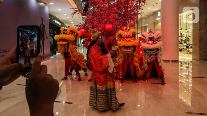 Pengunjung mengabadikan Kelompok Barongsai yang beraksi untuk merayakan Tahun Baru Imlek 2572 di Senayan City mall, Jakarta, Jumat (12/2/2021). Selain menghibur, atraksi barongsai juga dipercaya masyarakat Tionghoa mampu mengusir roh-roh jahat yang mengganggu. (Liputan6.com/Johan Tallo)