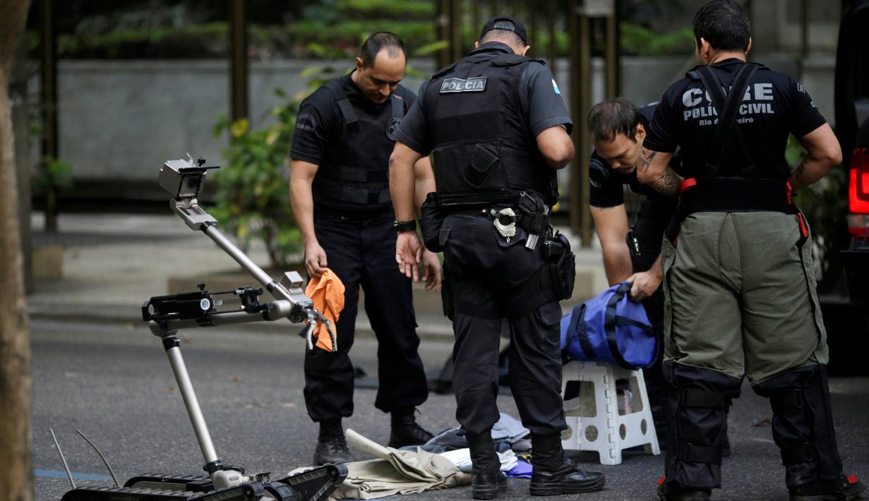 Petugas kepolisian Brasil memeriksa isi dari tas mencurigakan yang ditemukan jelang Olimpiade Rio de Janiero 2016, di dekat pantai Leblon, Rio de Janeiro, Senin (18/7). Sebelumnya tas tersebut diduga berisi bahan peledak. (REUTERS/Ricardo Moraes)