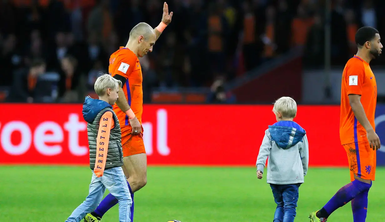 Gelandang Belanda, Arjen Robben bersama anaknya usai pertandingan melawan Swedia pada kualifikasi Piala Dunia 2018 di stadion Arena, Amsterdam (10/10). Dua gol yang dicetak Robben gagal mengantar Der Oranje lolos. (AP Photo/Peter Dejong)