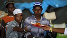 Para pengungsi etnis Rohingya saat menerima makanan di tempat penampungan, Kuala Langsa, Aceh (25/5/2015). Pemerinta RI mengalokasikan bantuan sebesar Rp 2,3 Miliar untuk pengungsi Rohingya yang berada di Aceh. (Reuters/Darren Whiteside)